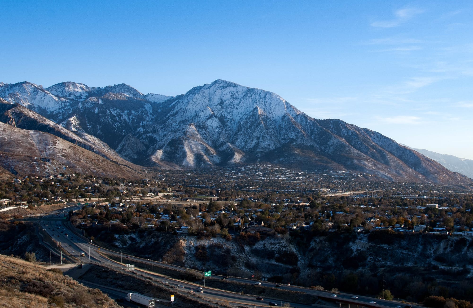 A view of the Wasatch Mountains, taken in early November, showcasing the neighborhoods nestled up against the slopes, and the beginnings of a snowy winter.